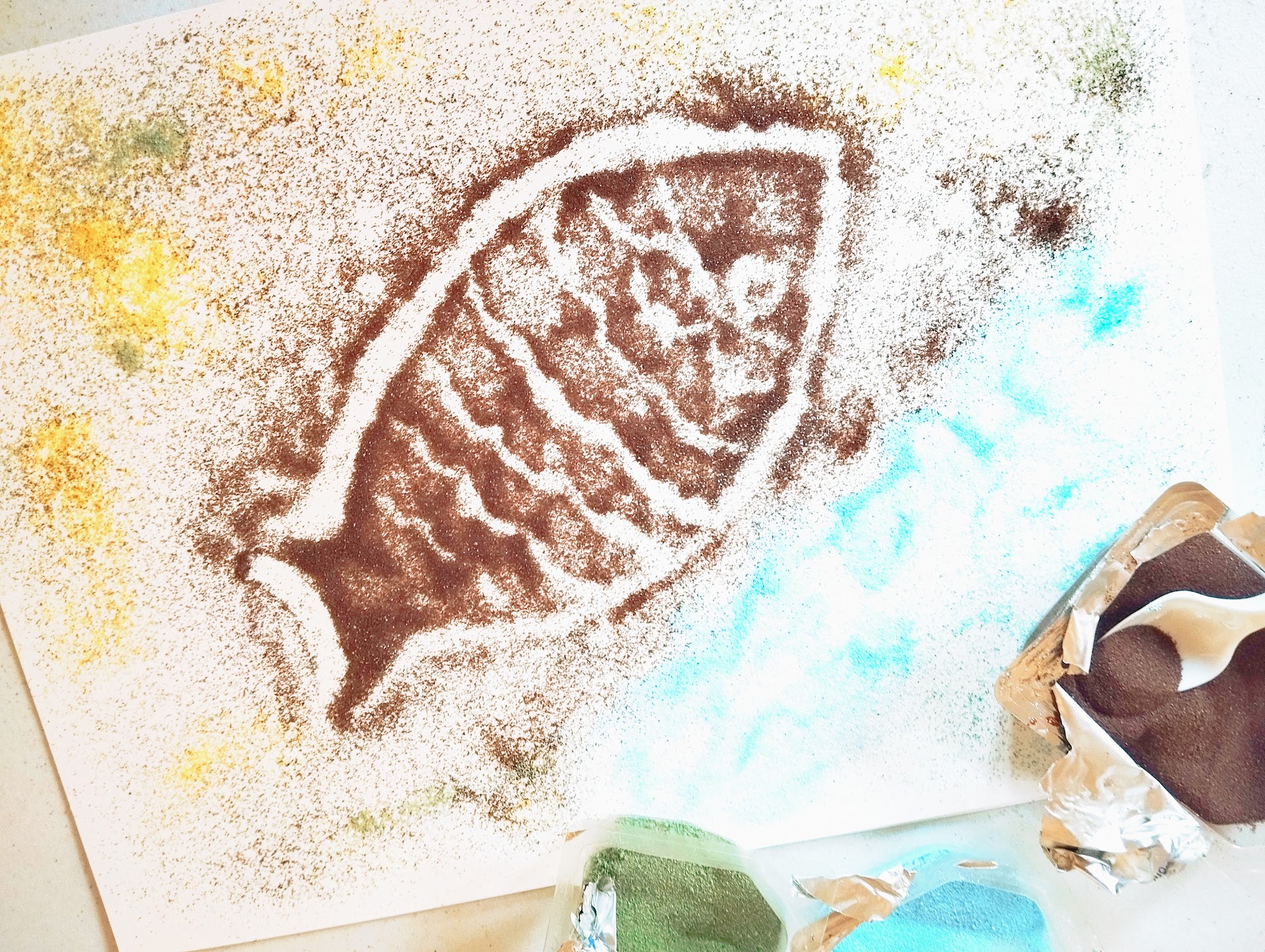 Un poisson dessiné sur le sable